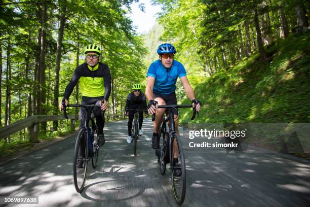 three men riding road bikes on mountain road - glases group nature stock pictures, royalty-free photos & images