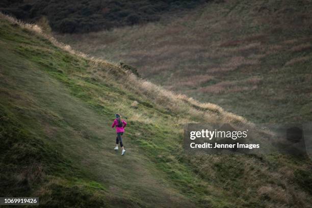 a woman out running up a mountain trail. - midlothian schottland stock-fotos und bilder
