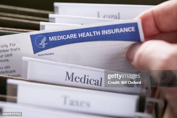 tarjeta de seguro médico de medicare en carpeta de archivos - medicare fotografías e imágenes de stock
