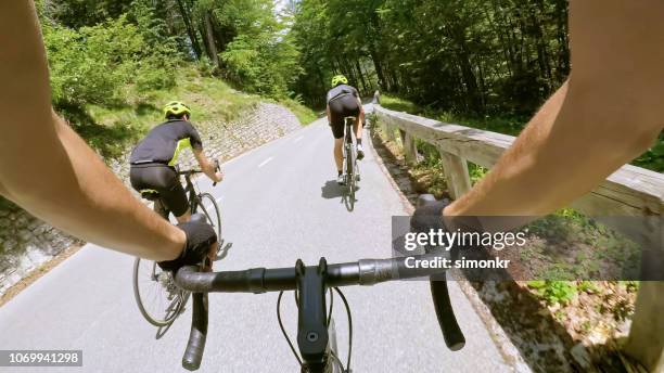 three men riding road bikes on mountain road - cycling shorts stock pictures, royalty-free photos & images