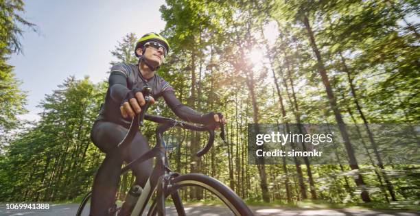 man riding road bike on mountain road - road cycling stock pictures, royalty-free photos & images