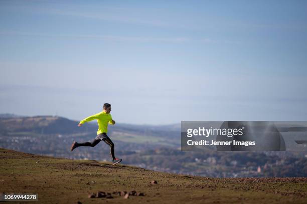 fit asian man out running on a mountain trail. - compression garment stock pictures, royalty-free photos & images
