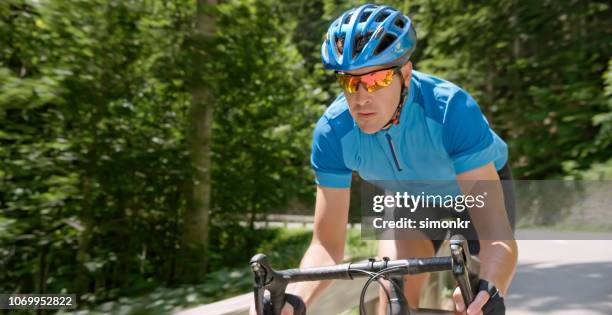 man paardrijden racefiets op bergweg - wielrennen stockfoto's en -beelden