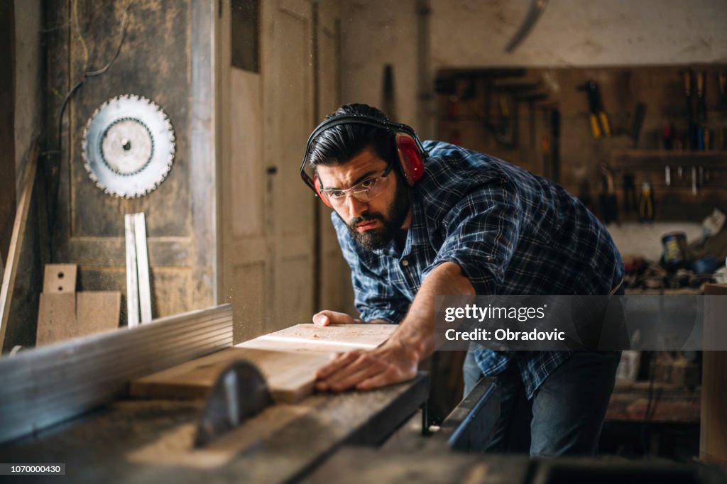 Zimmermann schneidet Holzplanke