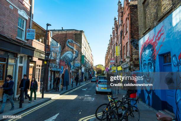 turistas caminando por la concurrida calle de brick lane, londres, reino unido - shoreditch fotografías e imágenes de stock