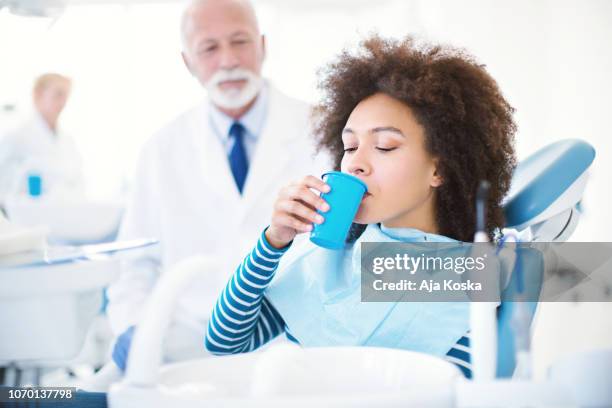 mundspülung während einer zahnärztlichen behandlung. - mundspülung stock-fotos und bilder
