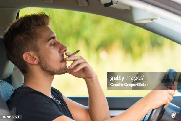 man met marihuana in de auto - steering wheel stockfoto's en -beelden