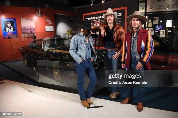 Cameron Duddy, Mark Wystrach and Jess Carson of Midland pose with the car from "Smokey And The Bandit" at the Country Music Hall of Fame and Museum...