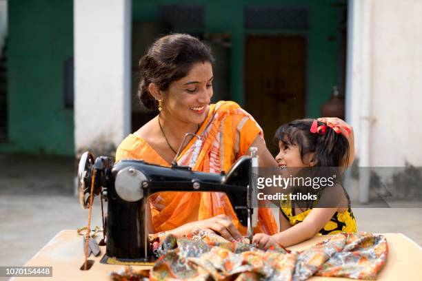 mother and daughter sewing clothes with sewing machine - village stock pictures, royalty-free photos & images