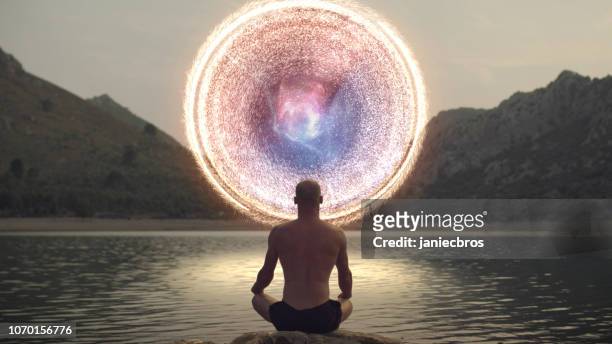 meditando l'uomo aprendo il portale all'energia cosmica. - belief foto e immagini stock