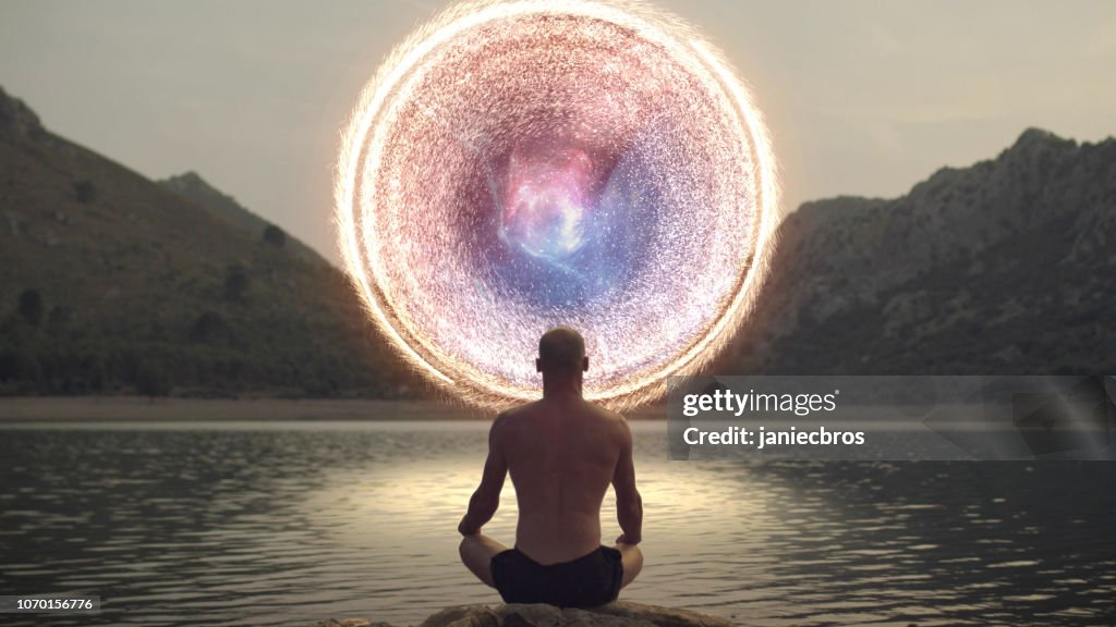 Meditating man opening portal to cosmic energy.