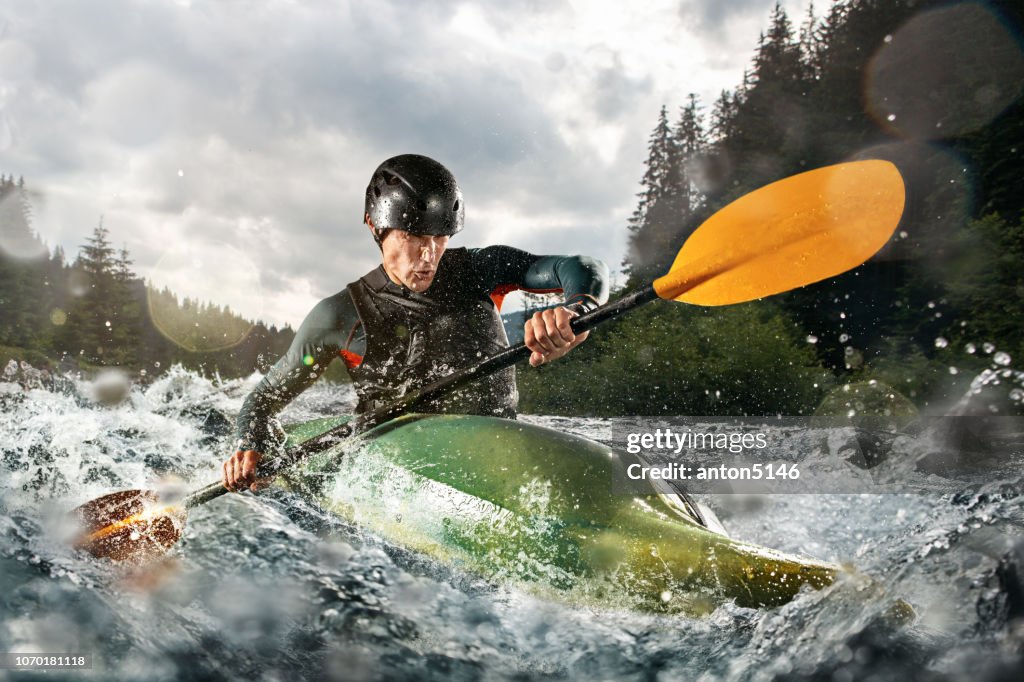 Wildwasser Kajak, Extreme Kajak. Ein Kerl in einem Kajak fährt auf einem Bergfluss