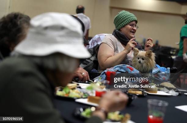 Guests dances with her dog as she enjoys a free Thanksgiving meal during the 27th Annual Thanksgiving Dinner for the community on November 20, 2018...