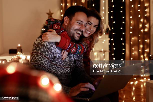 weihnachten glück zu hause - surfen und einkaufen - couple in evening clothes stock-fotos und bilder