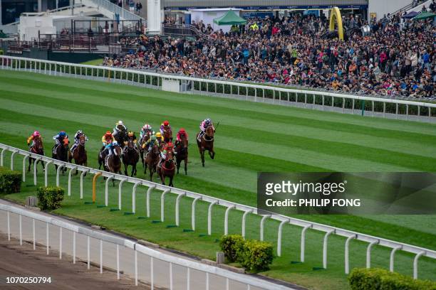 Jockeys compete in a horse race during the Longines International Races at Sha Tin race course in Hong Kong on December 9, 2018.