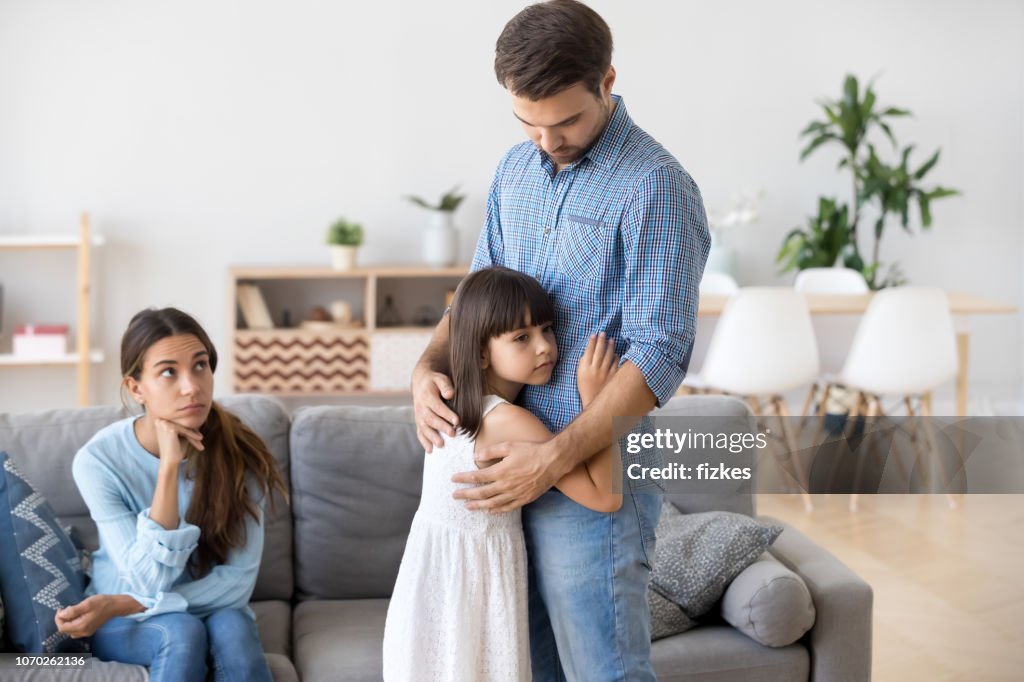 Unhappy family in living room daughter embrace father