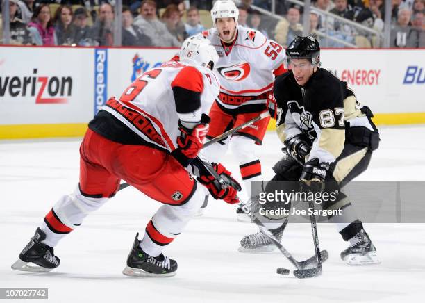 Sidney Crosby of the Pittsburgh Penguins moves the puck between the defense of Tim Gleason and Chad Larose of the Carolina Hurricanes on November 19,...