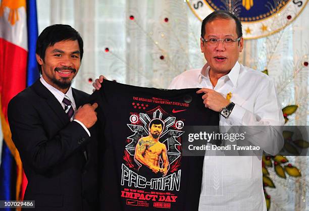 Boxer and congressman, Manny Pacquiao gives President Benigno Aquino III a shirt and memorabilia following his win of the WBC super welterweight...