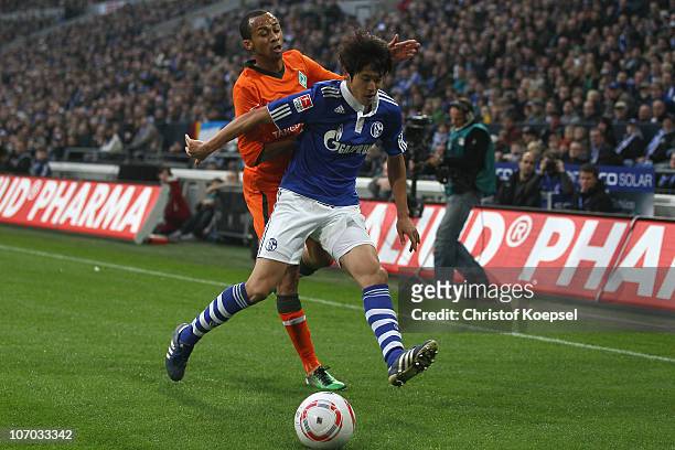 Wesley of Bremen challenges Atsuto Uchida of Schalke during the Bundesliga match between FC Schalke 04 and SV Werder Bremen at Veltins Arena on...