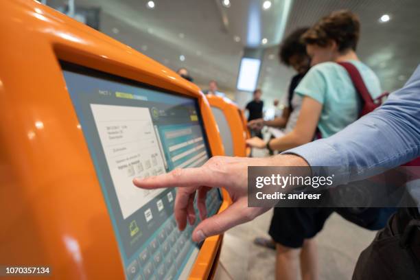 reisende, die tun einem self-check-in am flughafen - interactive kiosk stock-fotos und bilder