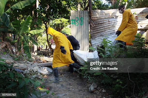 Members of a Haitian Ministry of Health body collection team carry the body of Nixon Merise through a small stream on their way to their vehicle for...