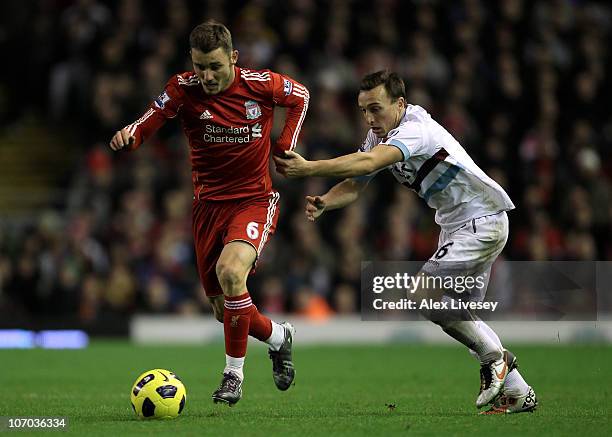 Mark Noble of West Ham United challenges Fabio Aurelio of Liverpool during the Barclays Premier League match between Liverpool and West Ham United at...