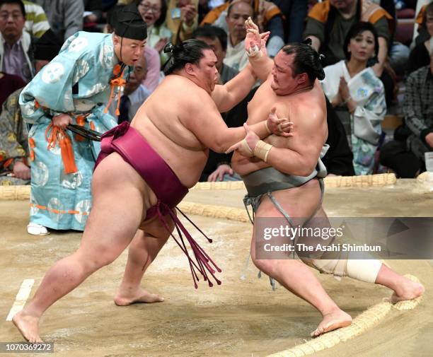 Sekiwake Mitakeumi pushes Hokutofuji out of the ring to win on day six of the Grand Sumo Kyushu Tournament at Fukuoka Convention Center on November...