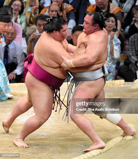 Sekiwake Mitakeumi pushes Hokutofuji out of the ring to win on day six of the Grand Sumo Kyushu Tournament at Fukuoka Convention Center on November...