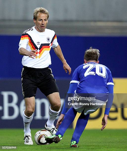 Juergen Klinsmann of the World Champion 1990 battles for the ball with Joerg Schwanke of the DFV Legend during the Reunification match between the...