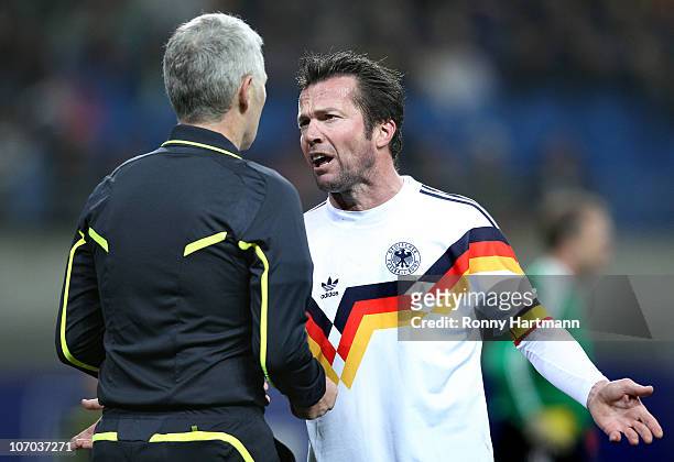Lothar Matthaeus of the World Champion 1990 discusses with referee Lutz Michael Froehlich during the Reunification match between the World Champion...