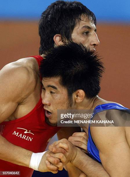 Reihanpour Soryan of Iran fights with Choi Gyujin of South Korea during the wrestling men�s Greco-Roman 55 kg 1/8 finals at the 16th Asian Games in...