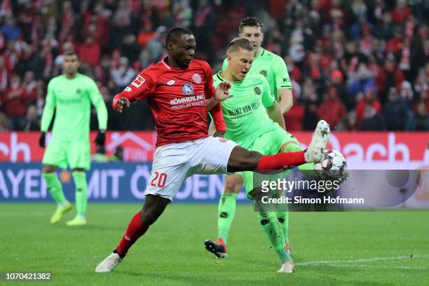 Anthony Ujah of FSV Mainz is challenged by Matthias Ostrzolek of Hannover 96 during the Bundesliga match between 1. FSV Mainz 05 and Hannover 96 at...