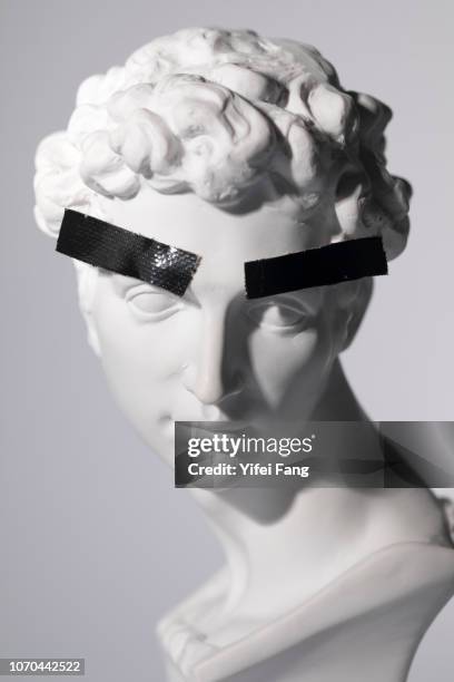 head sculpture with tape over eyebrows - bust sculpture stock-fotos und bilder