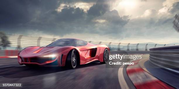 generic red sports car cornering around bend in racetrack - supercar stock pictures, royalty-free photos & images
