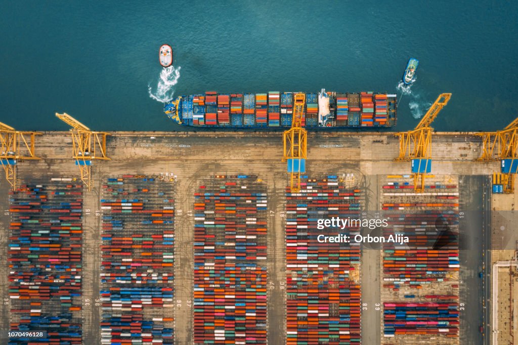 Veduta aerea del porto commerciale con container di carico gru a terra in nave merci.