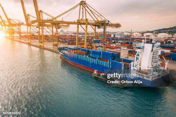 luchtfoto van zakelijke poort met wal kraan laden van containers in vrachtschip. - scheepswerf stockfoto's en -beelden