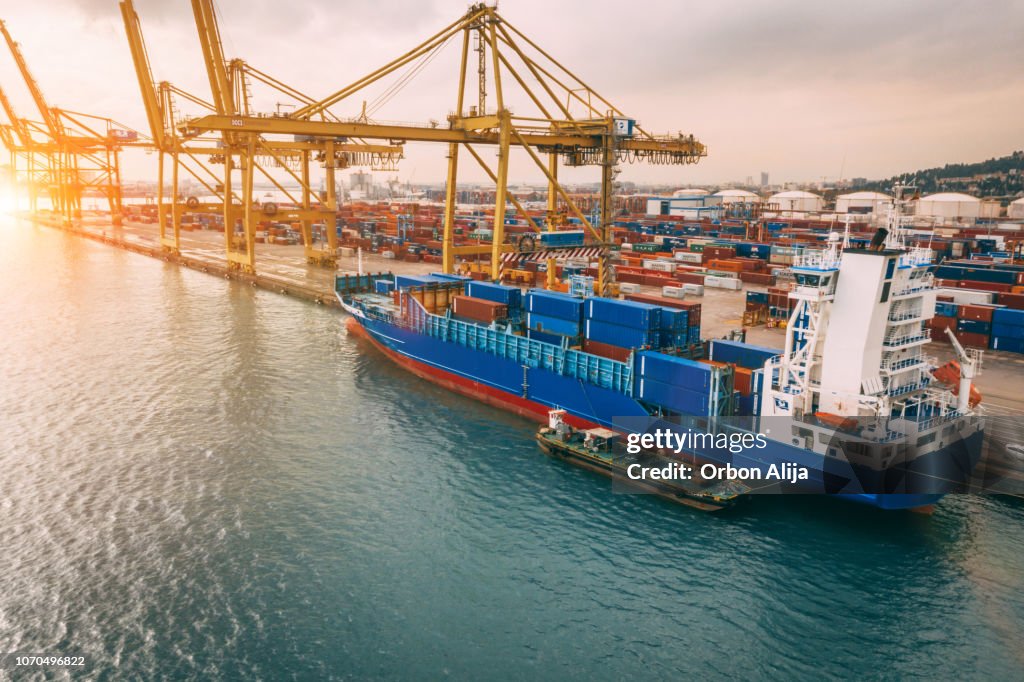 Vista aérea do porto de negócios com guindaste Shore carregar contêineres no navio de carga.