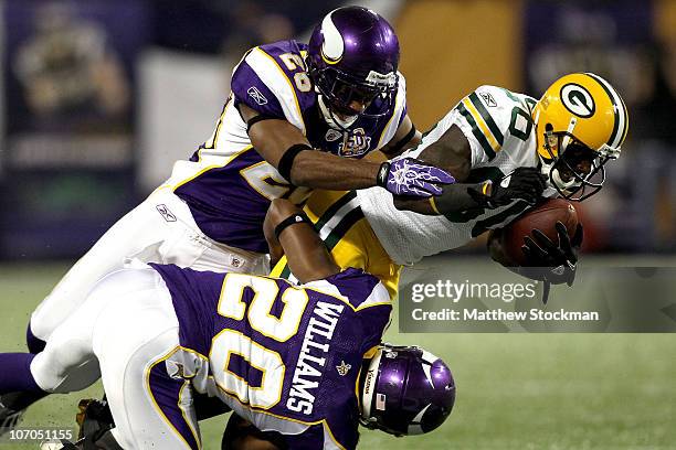 Donald Driver of the Green Bay Packers is brought down by Antonio Winfield and Madieu Williams of the Minnesota Vikings at the Hubert H. Humphrey...