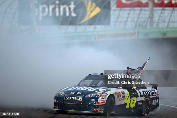 Jimmie Johnson, driver of the Lowe's Chevrolet, celebrates with a burnout after finishing in second place in the Ford 400 to clinch a fifth...