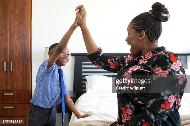 african mother and son high-five in bedroom - encouragement stock pictures, royalty-free photos & images