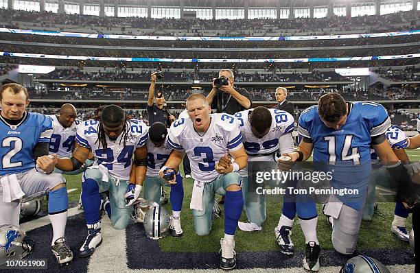 Quarterback Jon Kitna of the Dallas Cowboys leads a team prayer with punter Nick Harris, linebacker DeMarcus Ware, running back Marion Barber,...