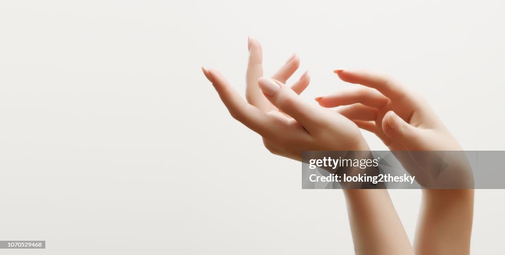Cuidado de la piel de mano. Primer plano de manos de mujer hermosa con luz manicura en uñas. Crema para manos y tratamiento.