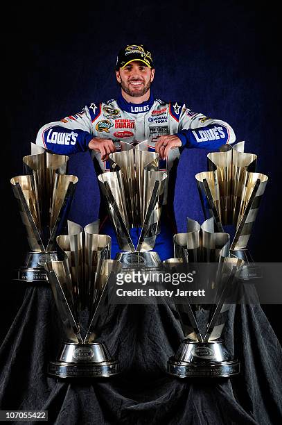 Champion Jimmie Johnson, driver of the Lowe's Chevrolet, poses with the Sprint Cup Series Championship trophies at Homestead-Miami Speedway on...