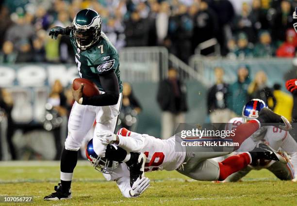 Michael Vick of the Philadelphia Eagles runs with the ball against Antrel Rolle of the New York Giants at Lincoln Financial Field on November 21,...