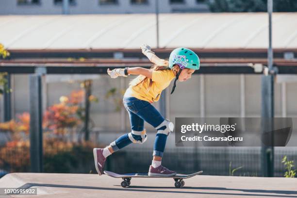 young girl riding a skateboard outdoors - skateboard park stock pictures, royalty-free photos & images