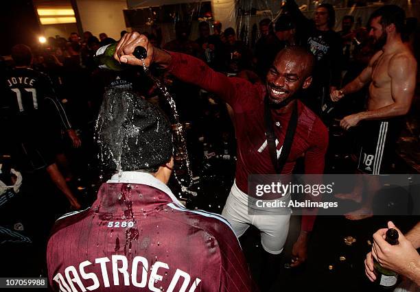 Omar Cummings of the Colorado Rapids pours champagne on caption Pablo Mastroeni while in the locker room celebrating their 2-1 overtime victory over...