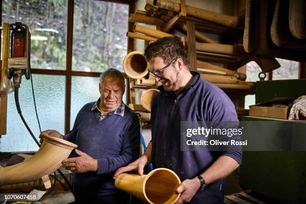 old and young instrument maker in workshop working on alpenhorn - alphorn stock-fotos und bilder