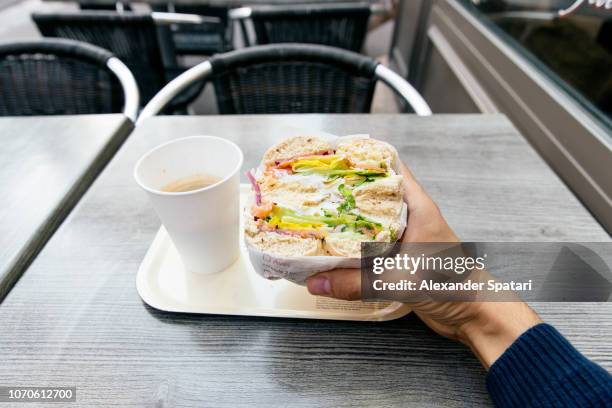 personal perspective of a man eating bagel with salmon and creme cheese - fastfood restaurant table stock-fotos und bilder