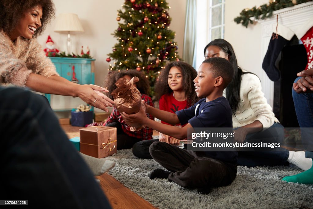 Son Giving Mother Gift As Multi Generation Family Celebrate Christmas At Home Together