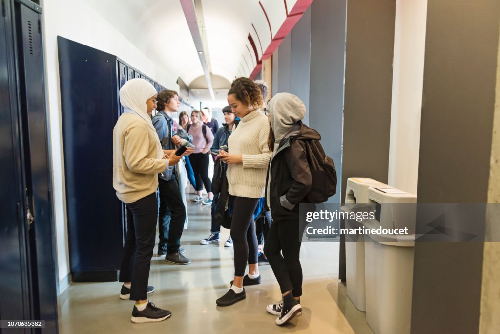 Multi-ethnic group of students hanging in College hall.